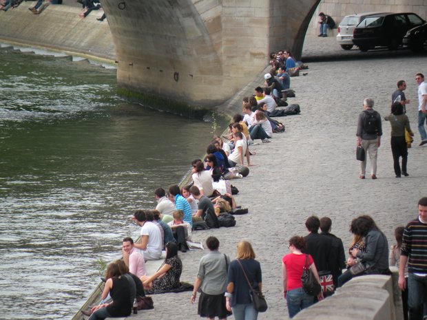  jeunes filles et jeunes hommes assis au bord de la Seine